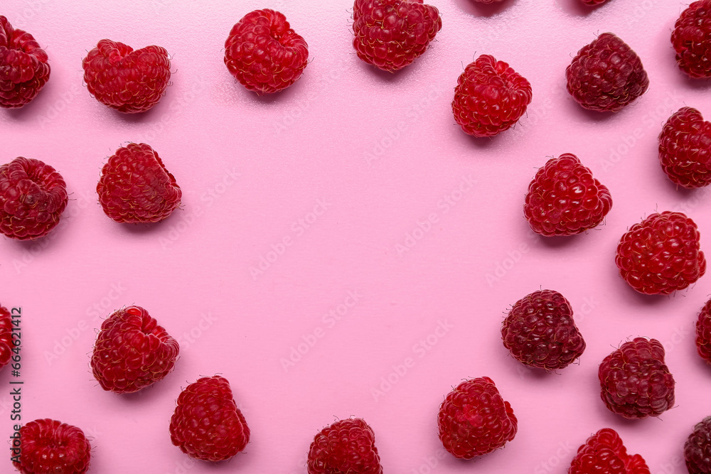 Frame made of fresh ripe raspberries on pink background