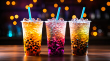Closeup of  three colorful milk-free bubble / boba tea cocktail drinks on a table
