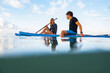 Young man and woman on the sea with a paddle surf board