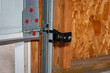 Overhead garage door opener safety sensor installed on roller track. Home safety, repair and maintenance concept.