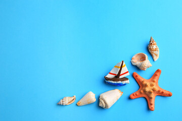 Poster - Beautiful starfish, decorative ship and shells on blue background, flat lay. Space for text