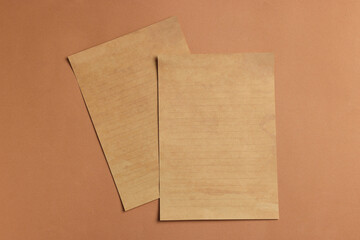 Canvas Print - Sheets of old parchment paper on brown background, flat lay