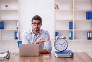 Wall Mural - Young male employee in time management concept