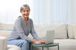© New Africa - Beautiful senior woman using laptop at home