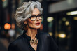 Elegant stylish senior businesswoman on a city street, portrait of a beautiful middle-aged woman with glasses and gray short hairstyle outdoors