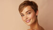 © ALA - Portrait of a beautiful, sexy smiling Caucasian woman with perfect skin and short haircut, on a creamy beige background.