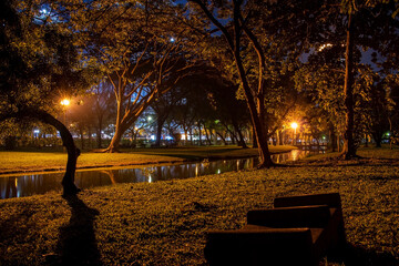 quiet orange park at night with river and trees