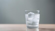 chill glass of water with ice in gray background.