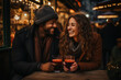 couple souriant et amoureux qui déguste un vin chaud au traditionnel marché de Noël