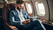 With tablet in hands. Businessman sits in a luxurious first class airplane