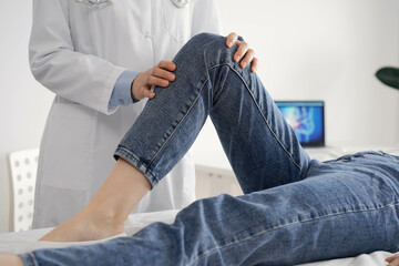 Wall Mural - Doctor and patient are at the usual medical inspection in the clinic. Therapist examines a young woman's knee. Medicine concept