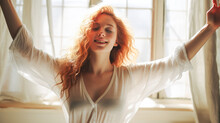 Redhead Woman In White Pajamas Stretching On A Minimalist Bed In Morning Light.