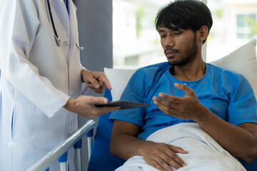 Young man with fever lying in bed with her shaking in hospital background Sick male patient lying in bed with doctor taking care of him, health insurance concept.