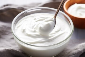 Wall Mural - stirring greek yogurt in a bowl with a spoon