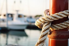 close-up of nautical ropes tied on a bollard at the marina
