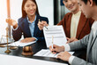 © laddawan - Business and lawyers discussing contract papers with brass scale on desk in office. Law, legal services, advice,  justice and law concept ..