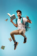 © PRASANNAPIX - Young and excited college boy running and jumping on white background