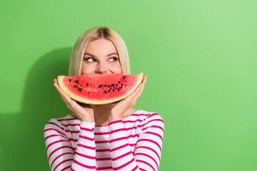 Sticker - Portrait of pretty girl with short hair dressed striped clothes eat tasty watermelon look empty space isolated on green color background