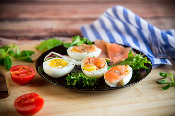 Wall Mural - boiled eggs with salted red fish, herbs and seasonings in a plate .