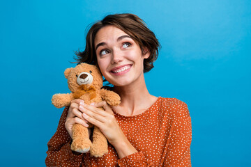 Sticker - Photo portrait of attractive young woman hold teddy bear look empty space wear trendy brown clothes isolated on blue color background