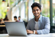 © PRASANNAPIX - Young college student using laptop, smiling