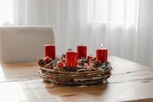Cozy modern home with advent wreath on wooden dining table. Celebrating winter time and days before Christmas in Switzerland.