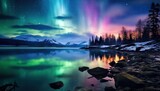 Green and pink aurora borealis over snow-capped mountains with reflection in a lake.