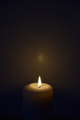 A candle flame with a dark background and copy space