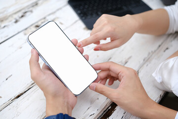 Poster - Overhead shot, Businessman using his cellphone, reading an informations or email on the phone screen at his desk. Phone white screen mockup.