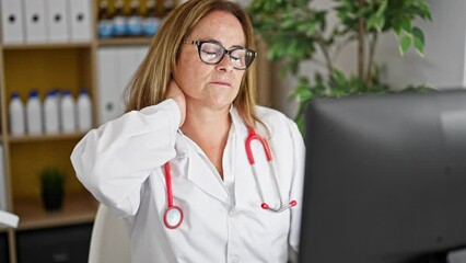 Canvas Print - Middle age hispanic woman doctor using computer suffering for cervical pain at the clinic