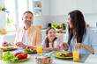 © deagreez - Photo of sweet adorable married couple small daughter communicating eating delicious dinner indoors home kitchen