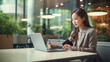© Alfonso Soler - Asian business woman working on a laptop in a professional office