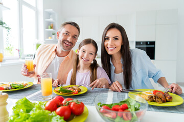 Sticker - Photo of cheerful charming married couple small daughter enjoying delicious supper indoors home kitchen