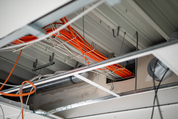 orange network cables run bundled under the ceiling.