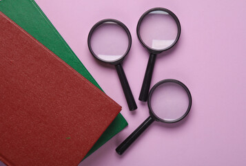 Sticker - Magnifiers with books on a purple background. Education concept