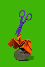 Scissors Over Paper On Rock Against A Green Background. Rock, Paper And Scissor Minimalist Concept