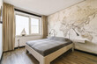 © ADDICTIVE STOCK - Bedroom with bed and map wallpaper by bright window