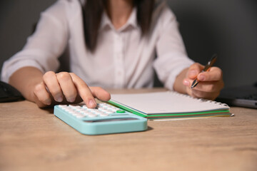 Wall Mural - female accountant calculating expenses at home, closeup