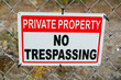 private property no trespassing sign tied to a metal fence