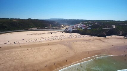 Wall Mural - Aerial video filming by drone of the sea bay and beach near village of Odeceixe Alentejo Portugal. Tourists on the beach and in the water.