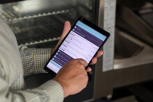 Chef Using IPad In Commercial Kitchen For Audit