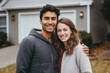 Portrait of a happy young couple in front of a house