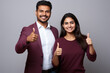 © vefimov - Picture of man and woman both smiling and giving thumbs up. This image can be used to represent success, agreement, or approval in various contexts.