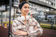 © Miljan Živković - One young sporty woman with headphones happy smile stand outdoor