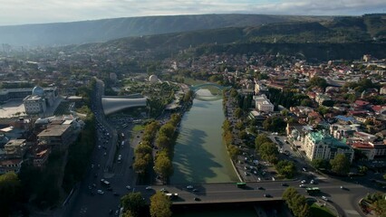 Wall Mural - 4k aerial tbilisi city footage just after sunrise with sun lights and blue clouds in the sky