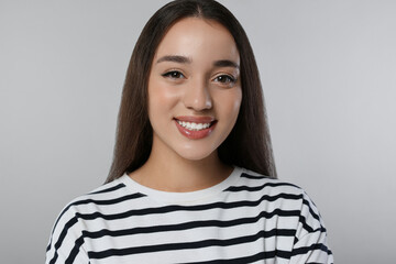 Wall Mural - Portrait of beautiful young woman on light grey background