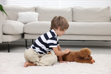 Wall Mural - Little child and cute puppy on carpet at home. Lovely pet