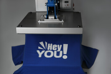 Wall Mural - Printing logo. Heat press with blue t-shirt on white table