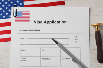 Wall Mural - Immigration to USA. Visa application form, flag, stamp and pen on white wooden table, flat lay