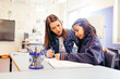 © Austockphoto - Aboriginal female school teacher sitting with her student in the classroom